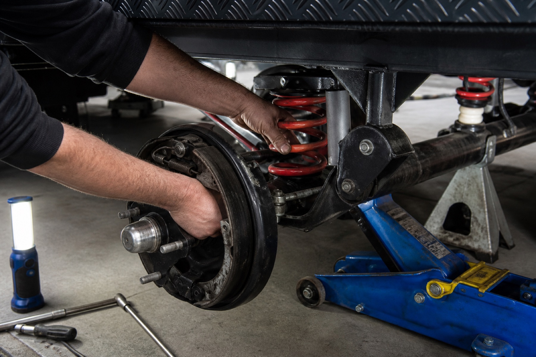 Close-up hands servicing caravan chassis brakes and suspension