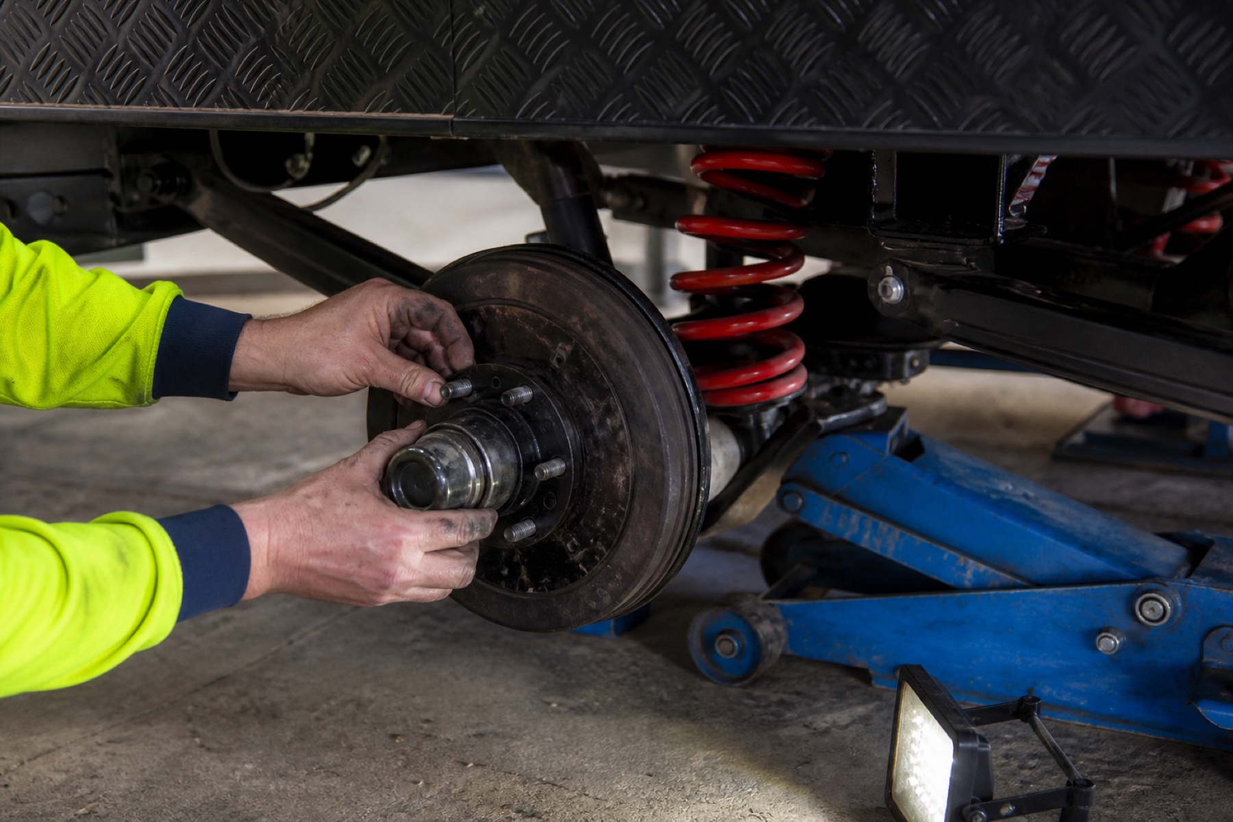 Close-up of technician hands servicing caravan wheel bearings